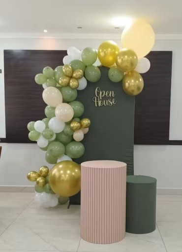 Arco de balões verde, branco e dourado com painel Open House